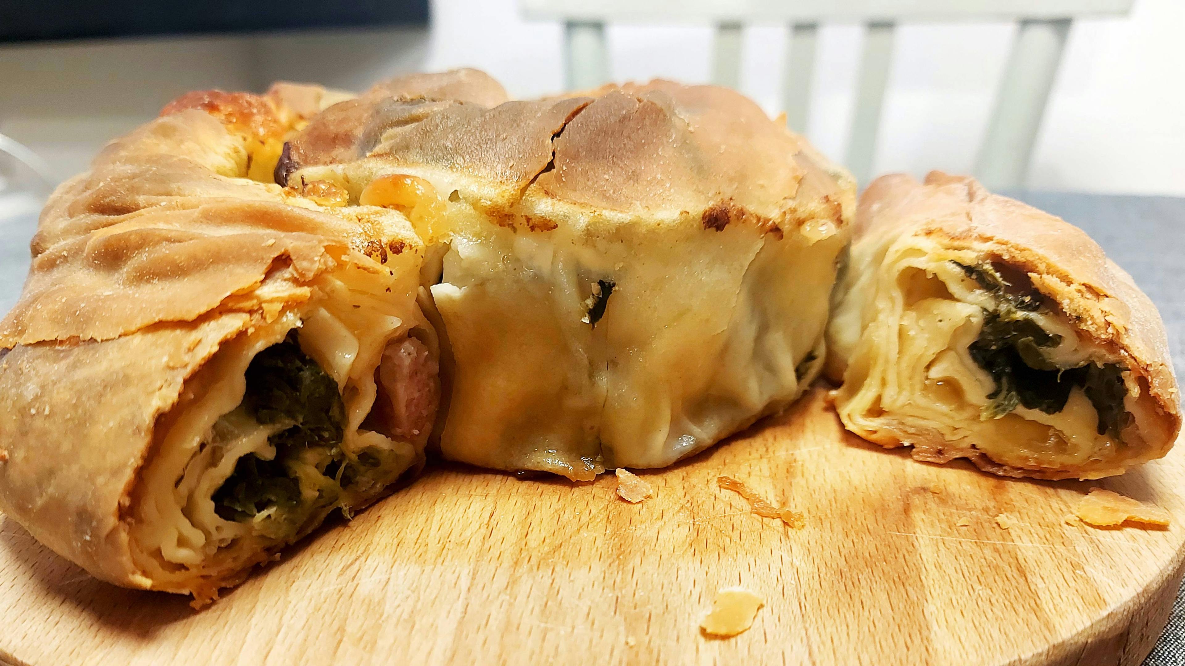 Pizza Rentorta, a rustic dish from central Italy, similar to a rolled strudel filled with a rich mix of sausage, boiled greens, and cheeses
