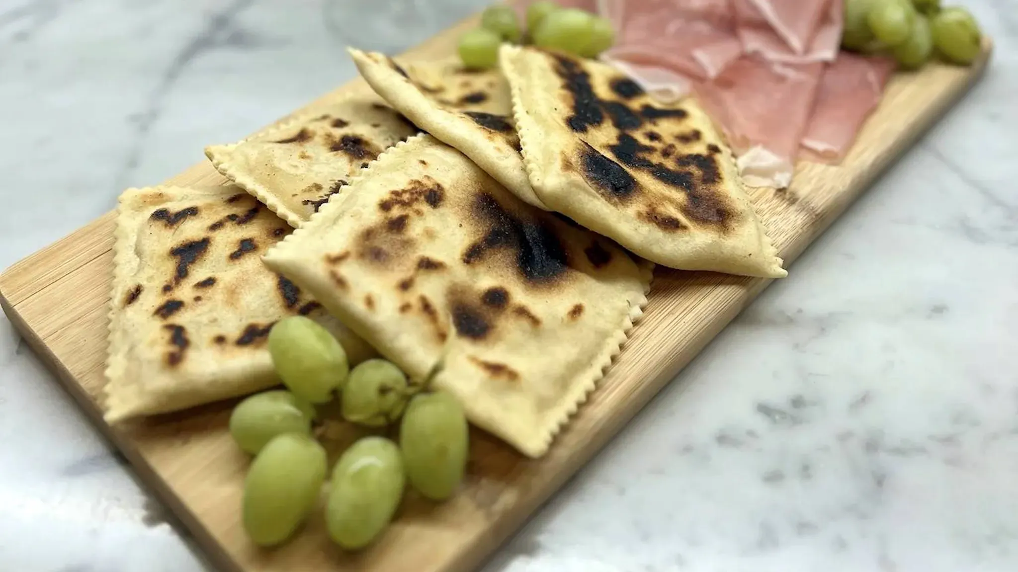 Tortelli alla lastra, an ancient Tuscan–Romagnolo Apennine recipe filled with potatoes and sausage. Easy, crispy, and irresistible