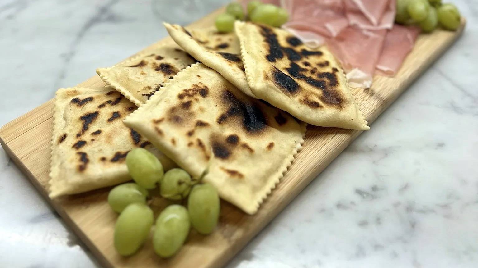 Tortelli alla lastra, an ancient Tuscan–Romagnolo Apennine recipe filled with potatoes and sausage. Easy, crispy, and irresistible