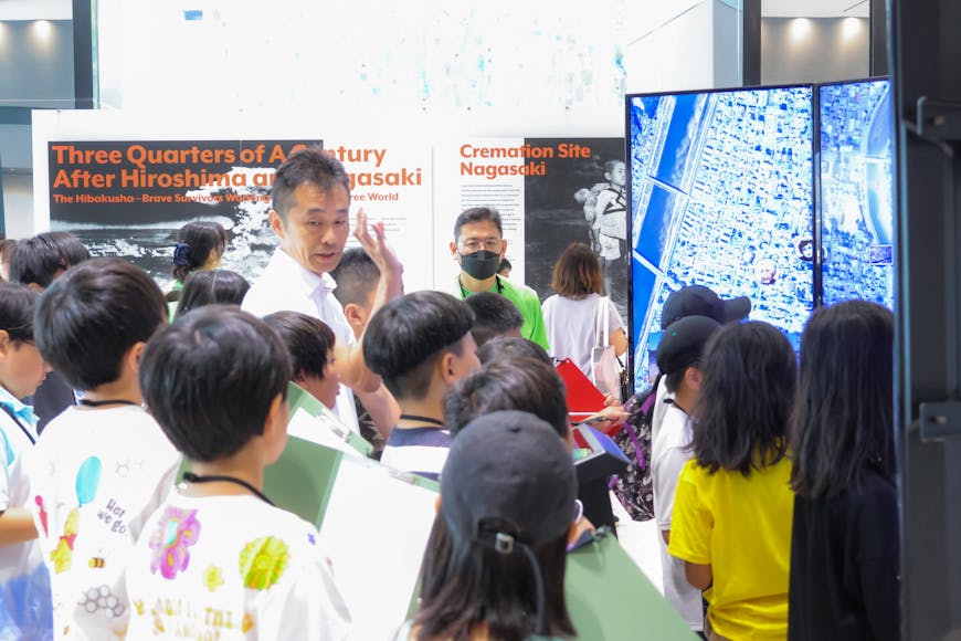 A group of students looking at a city map on large Liquid Galaxy screens