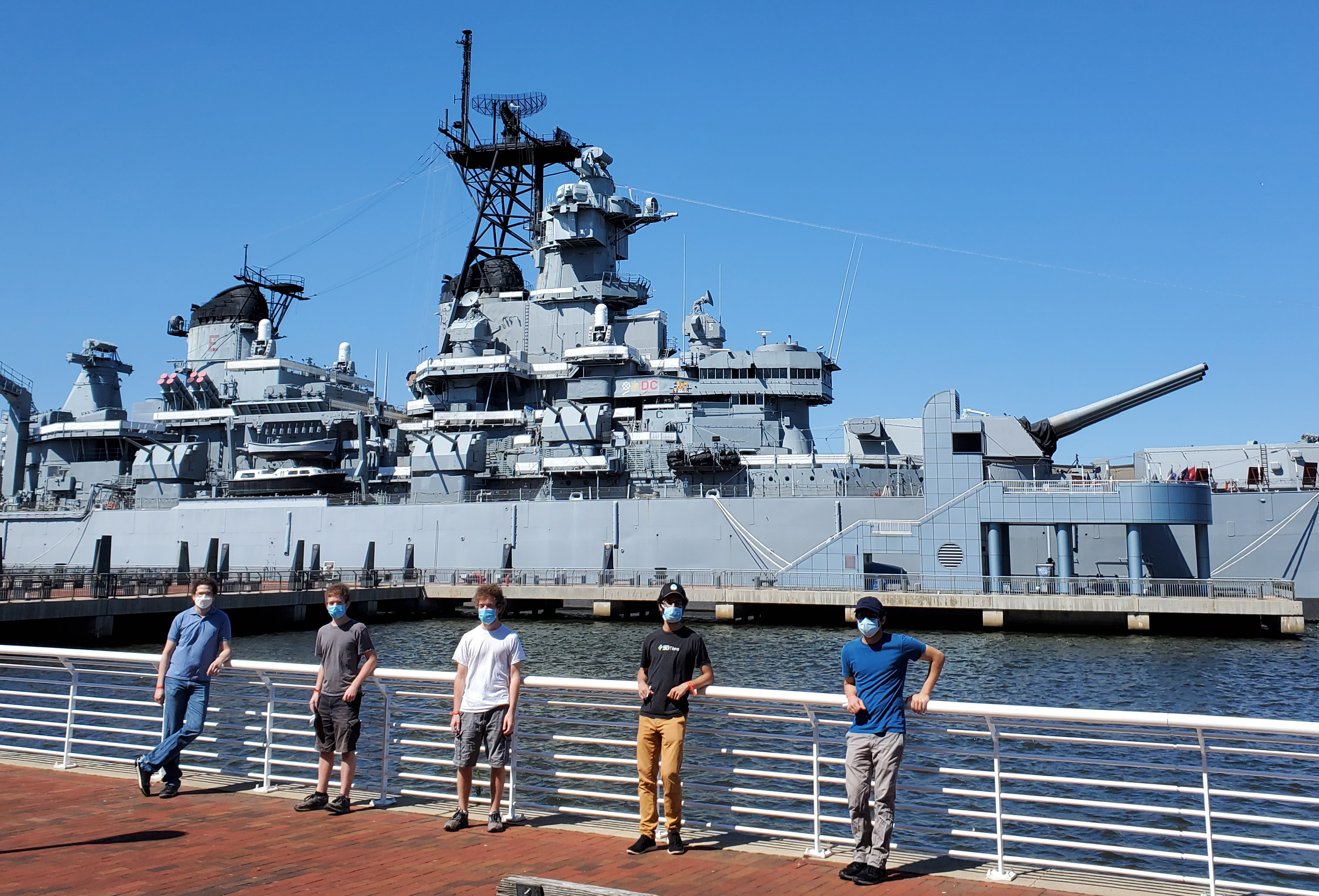 Five members of the Cesium team standing in front of the U.S. Battleship New Jersey outside of Philadelphia