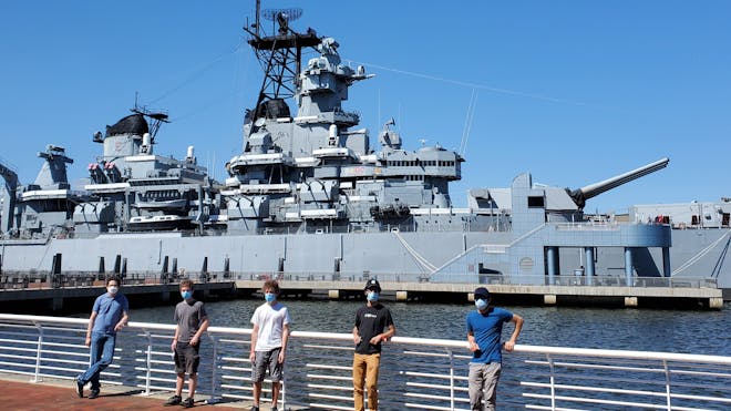 Five members of the Cesium team standing in front of the U.S. Battleship New Jersey outside of Philadelphia