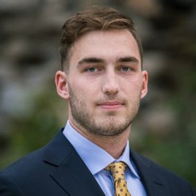 I man wears a suit and gold tie.