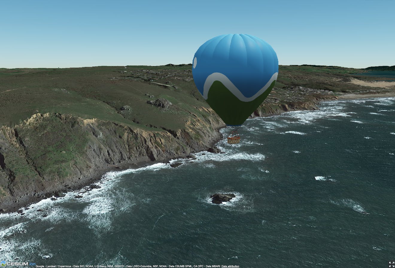 Hot air balloon with the Cesium logo off the coast of northern California, USA, using Photorealistic 3D Tiles in CesiumJS.