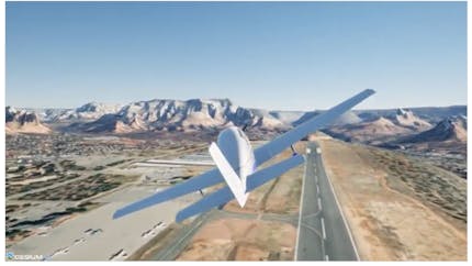 Fixed-wing aircraft flies above an airport, with mountains in the distance.