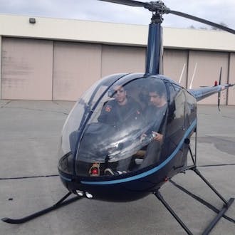 Sam Suhag in the cockpit of a grounded helicopter.