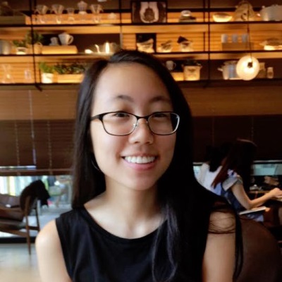 A woman with long hair and glasses smiles.