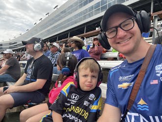 Jason Sobotka and his son at Texas Motor Speedway. They wear branded racing shirts and ear protection.