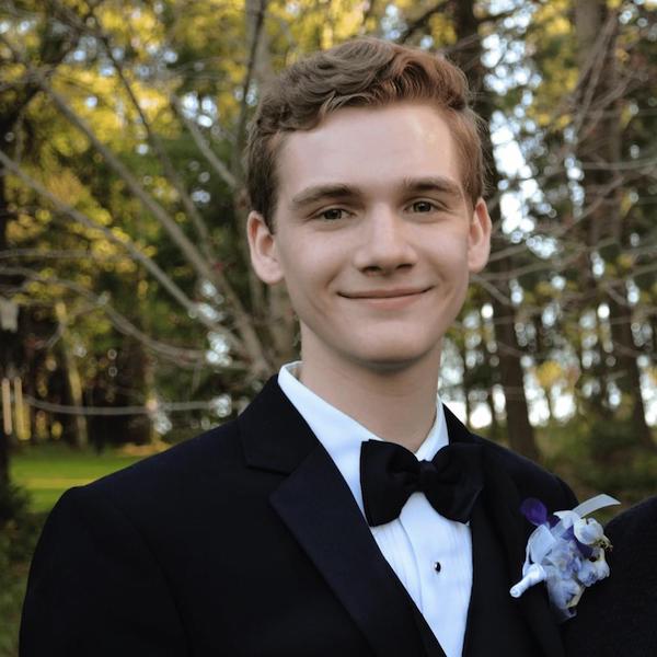 A man in a tuxedo smiles