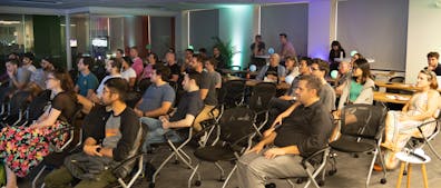 Crowd in seats in darkened event space at Cesium office