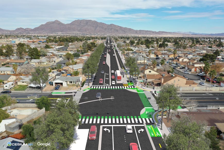 High-fidelity, photorealistic renderings by Parametrix of a proposed design helped the City of Las Vegas secure a $25 million grant for the Stewart Avenue Complete Streets project. Aerial view of a suburban neighborhood with a newly constructed multi-lane road running through the center. The road includes green-marked bike lanes, crosswalks, and traffic signals at intersections. Residential houses and trees line both sides, with mountains visible in the background under a partly cloudy sky. Logos for Cesium and Google appear in the bottom left corner.