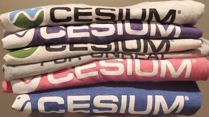 A colorful stack of Cesium tee shirts