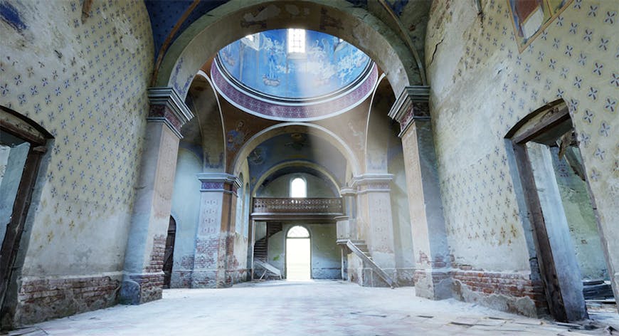 Interior view of the historic Oleszyce Church in Poland, looking up into a domed ceiling painted with blue artwork