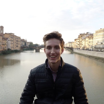 A man in a black puffy coat smiles.