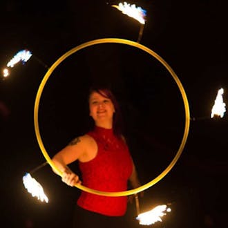 Hannah Pinkos spins a flaming hoop.