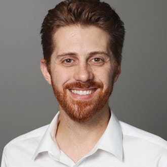 Ryan Veenstra, wearing a white collared shirt, dark hair, red beard