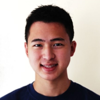 A man in a black shirt smiles.