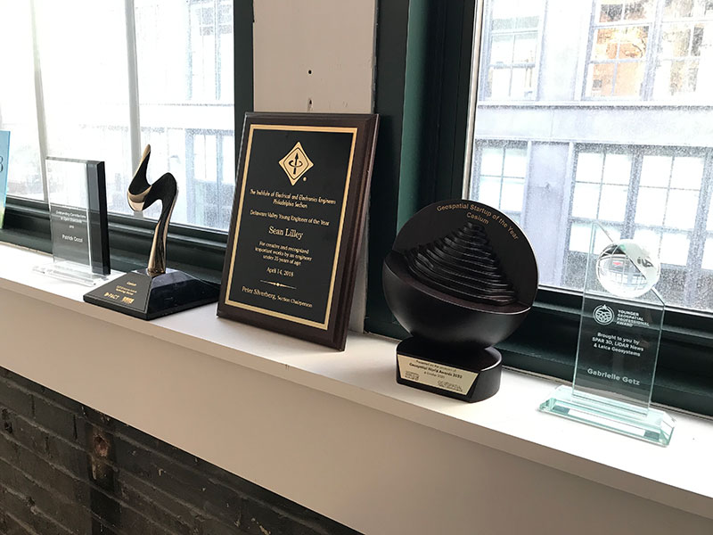 The Geospatial Startup of the Year and 2020 Technology Startup Enterprise Award trophies on a windowsill in downtown Philadelphia.