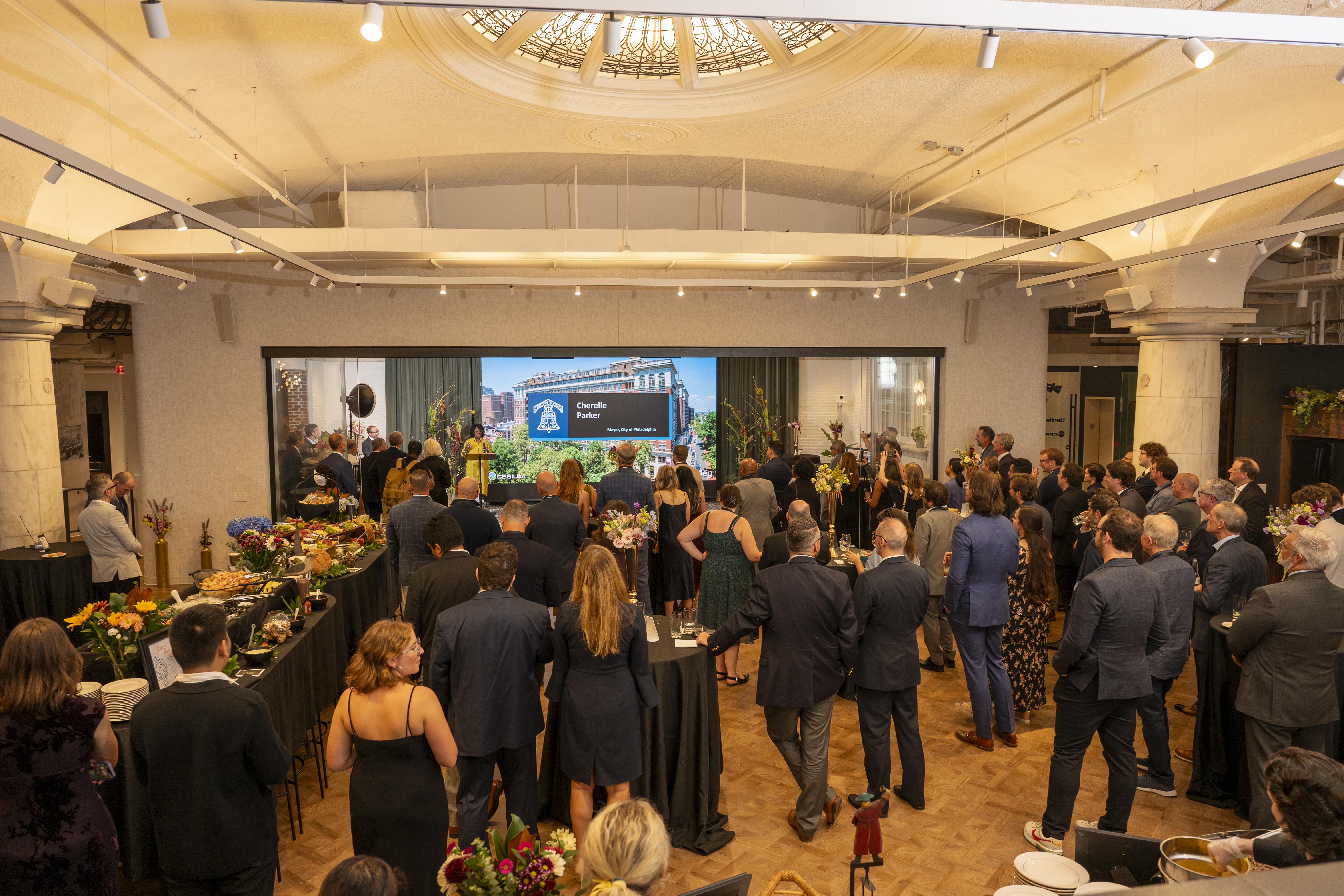 Crowd watching Patrick Cozzi emcee at the opening of the Philadelphia Bentley office at the Curtis Center