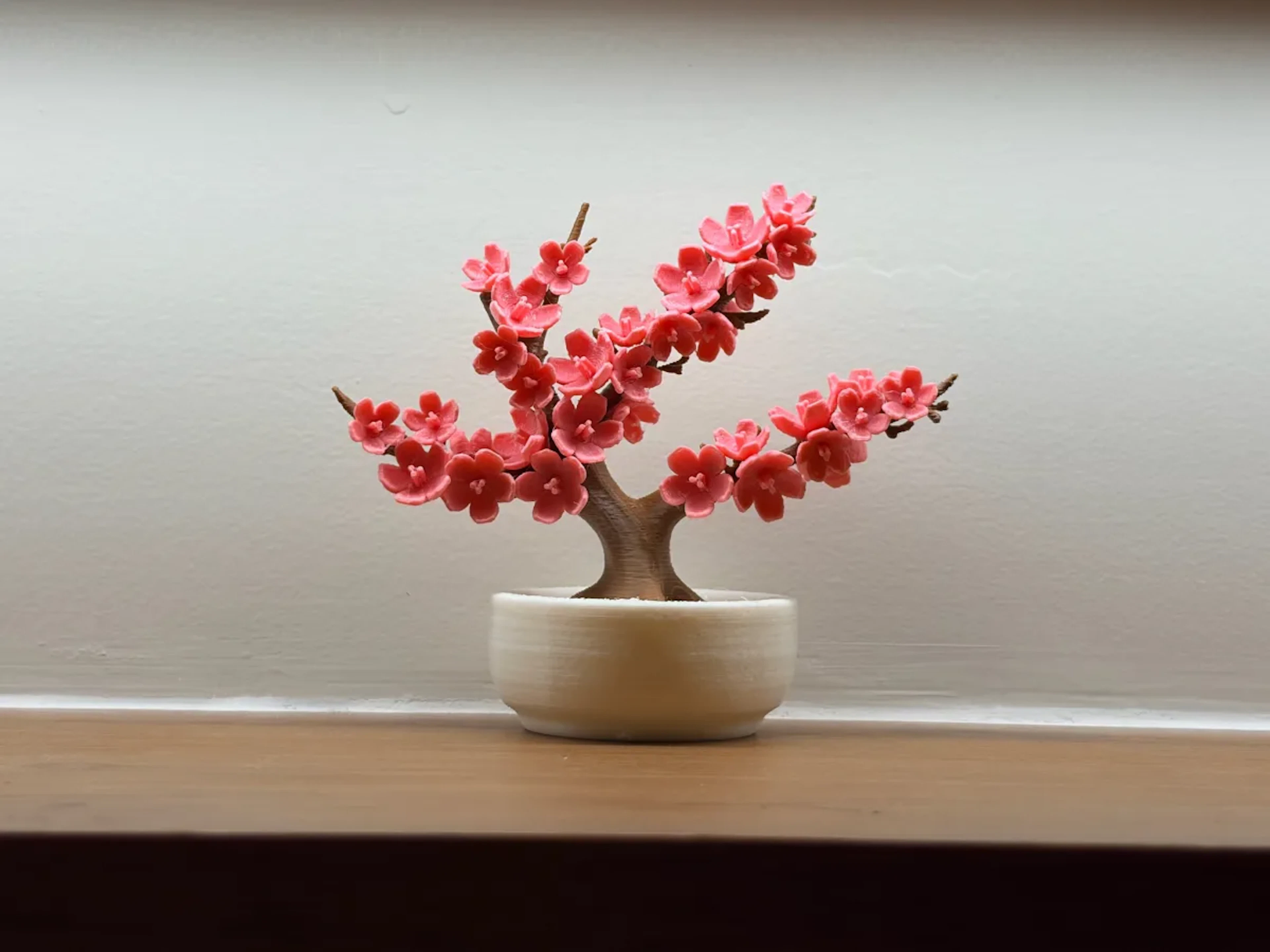 Cherry blossom bonsai printed in pink and brown, in a turned pot