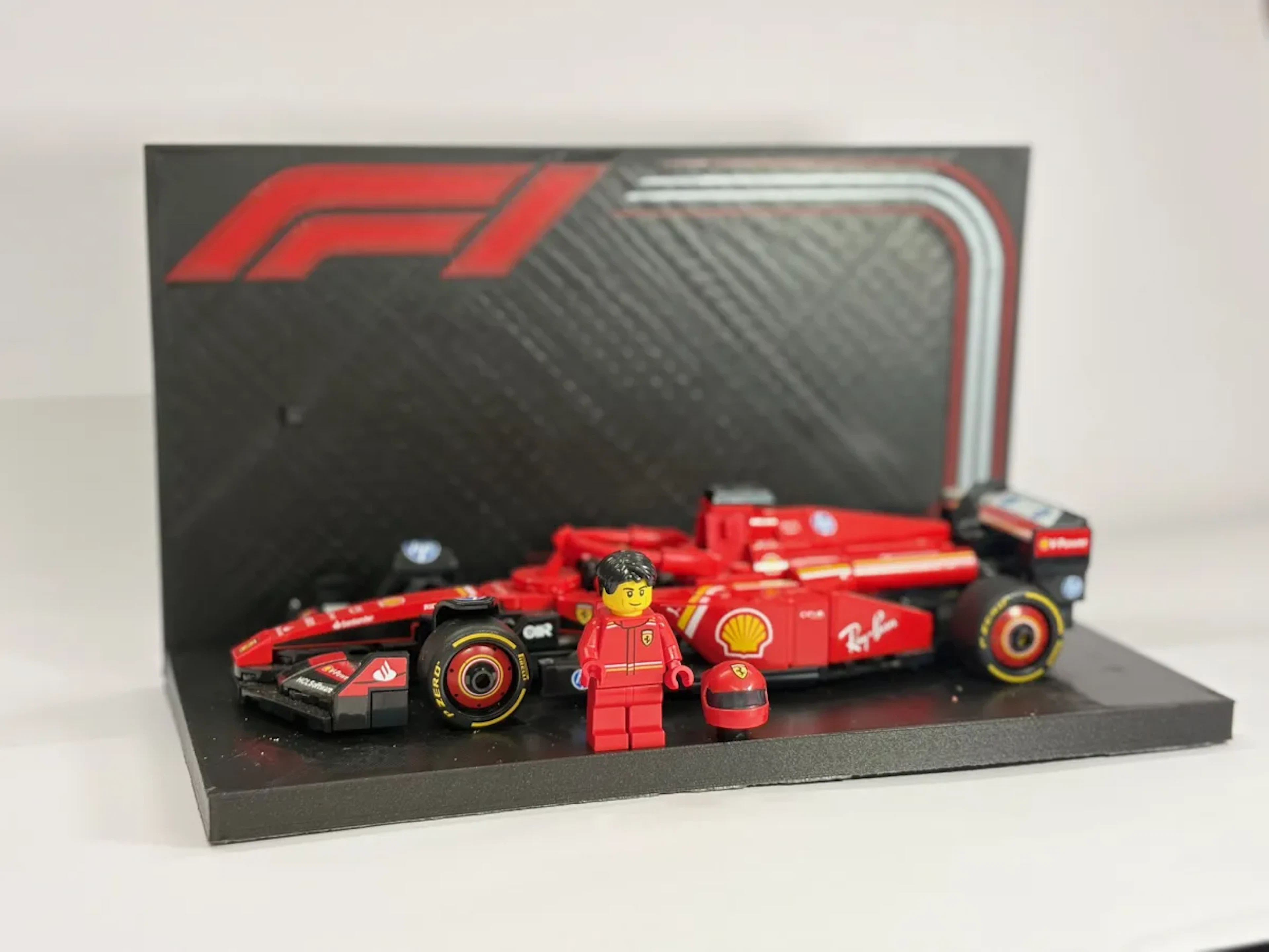 Formula 1 car model printed in red and black, mounted on a display base