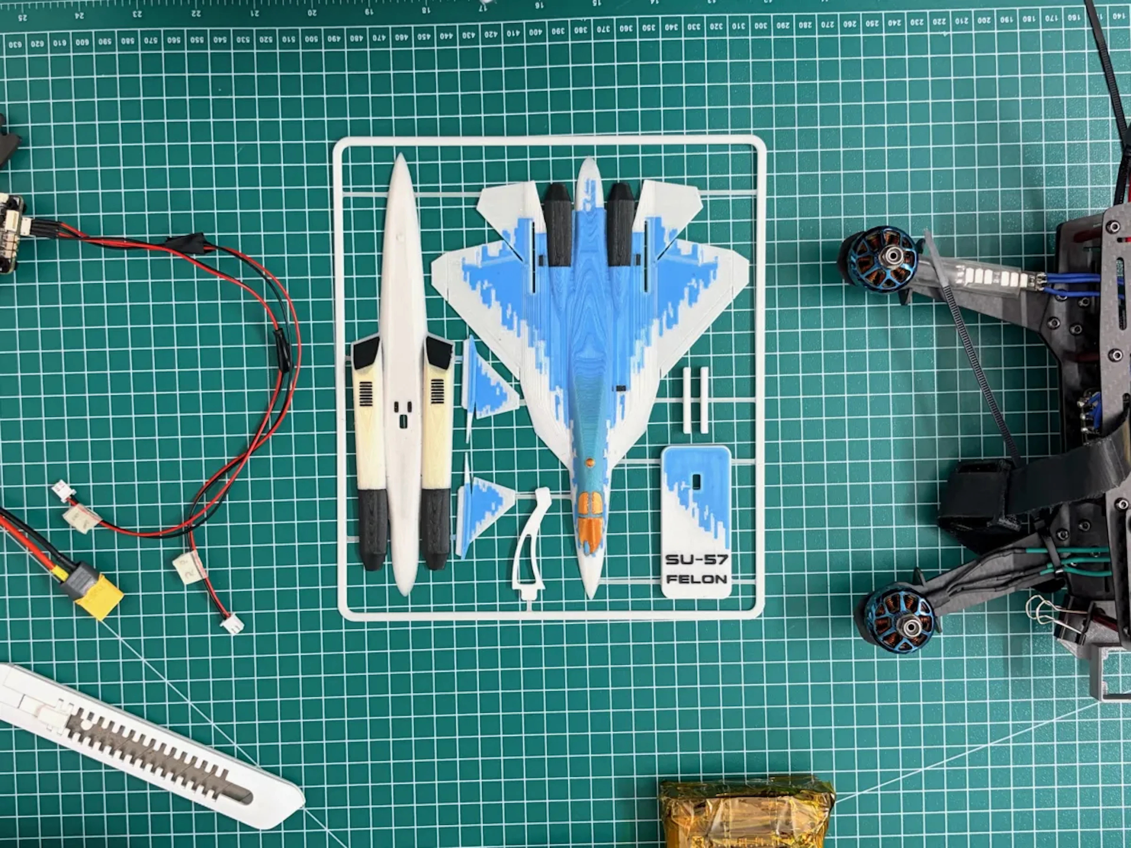 Model jet aircraft kit printed as a sprue, laid out on a cutting mat