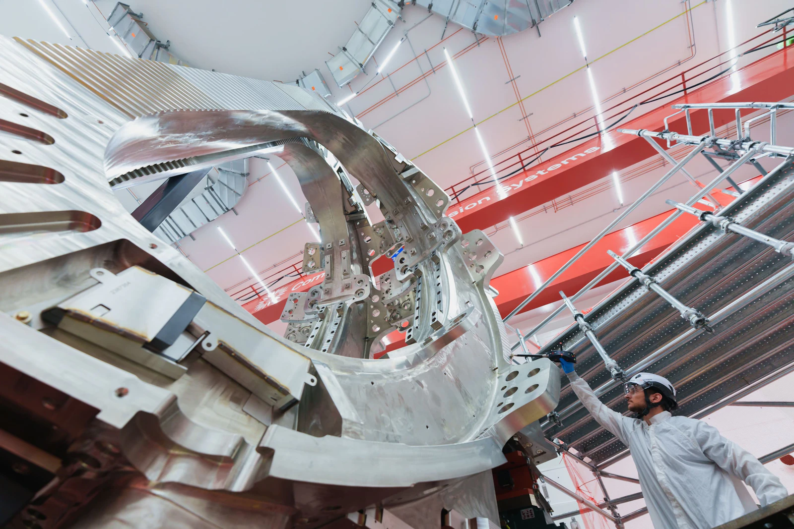 A technician standing next to one two of Commonwealth Fusion Systems' toroidal field magnets made with high-temperature superconducting tape. 