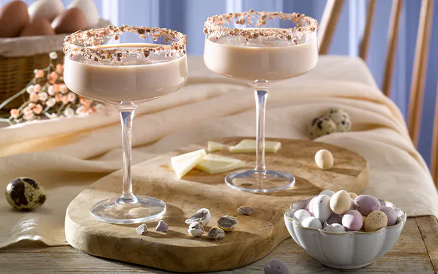 Mini Egg Martini cocktail in coupe glasses rimmed with crushed Mini Eggs 
