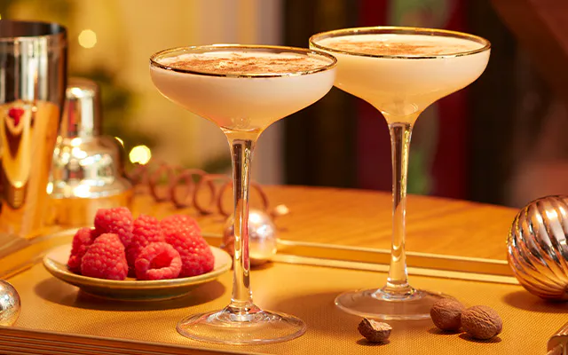 Maple Flip dessert cocktail in tall coupe glass and topped with ground nutmeg