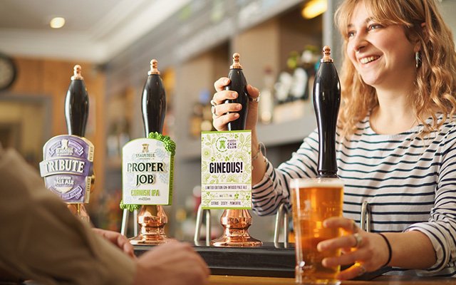 Woman pulling pint of gin infused beer