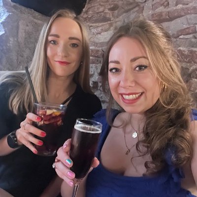 two smiling friends enjoying cocktails