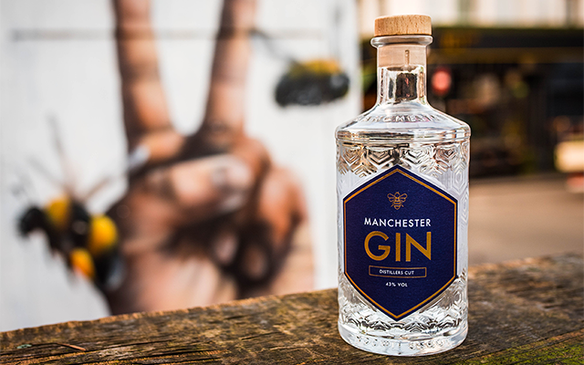 manchester gin distillers cut in front of graffiti of hands and bees.png