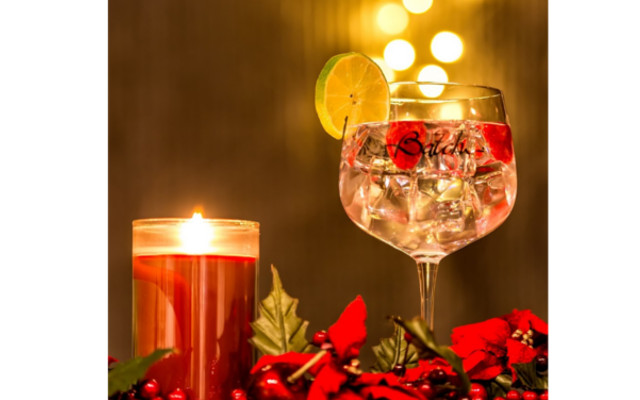 Batch gin perfect serve with raspberries and lime, scented christmas candel