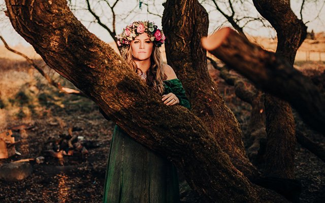 Woman with flower garland by tree