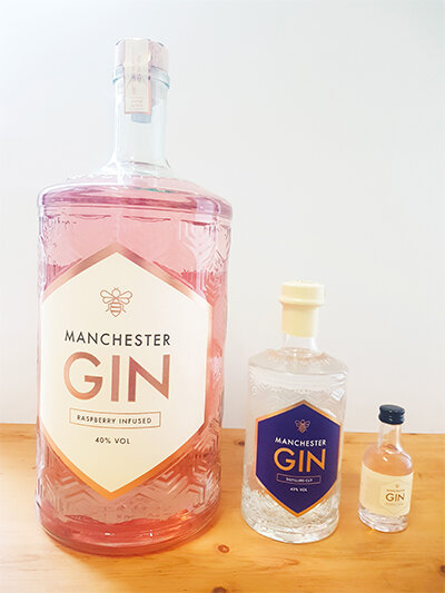 Manchester Gin’s Raspberry Jeroboam next to a standard full-size bottle of gin and a single-serve miniature bottle