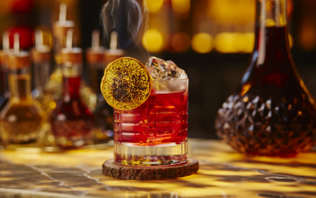 Negroni cocktail with dried lemon wheel garnish in tumbler