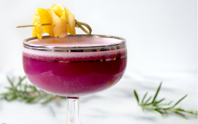 Purple blueberry gin sour with lemon garnish