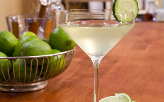 Gin and Lime gimlet in a coupe style glass cucumber garnish