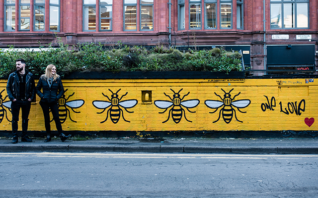 Seb Heeley and Jen Wiggins of Manchester Gin against bumble bee graffiti