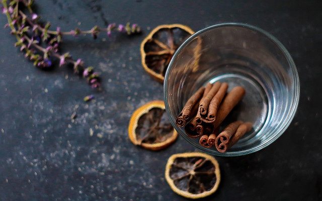 Cloves, cinnamon and orange in a glass