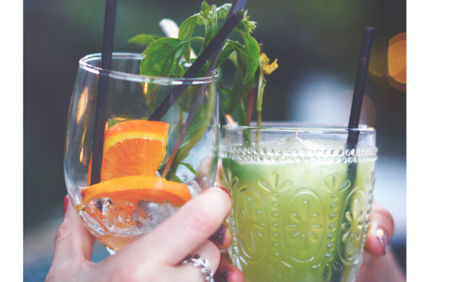 People cheersing with cocktails, green cocktails, hands