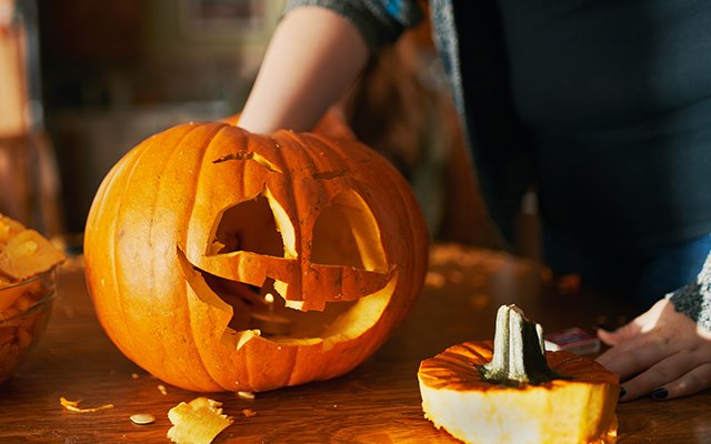 Woman carving a pumpkin