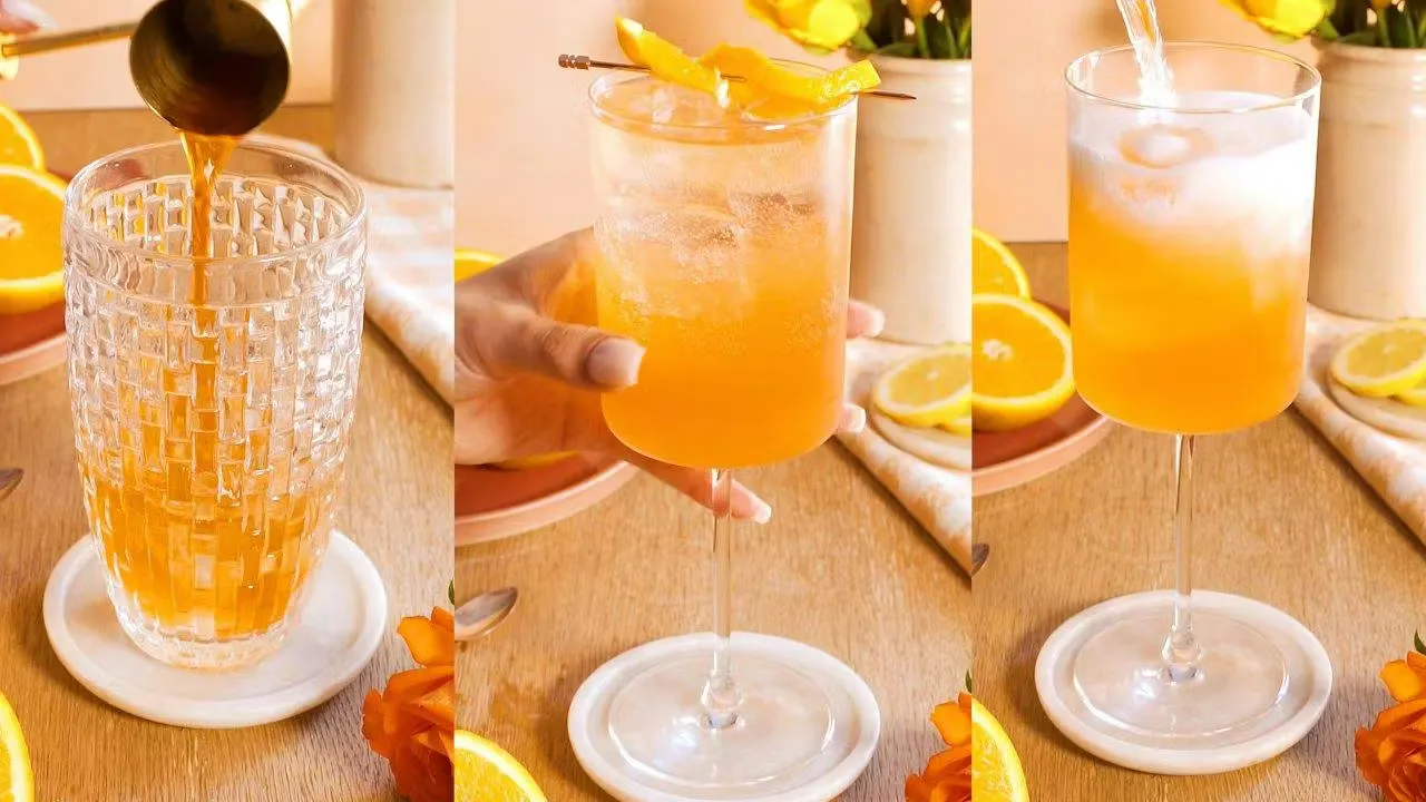 Orange spritz cocktail in a square wine glass with orange garnish