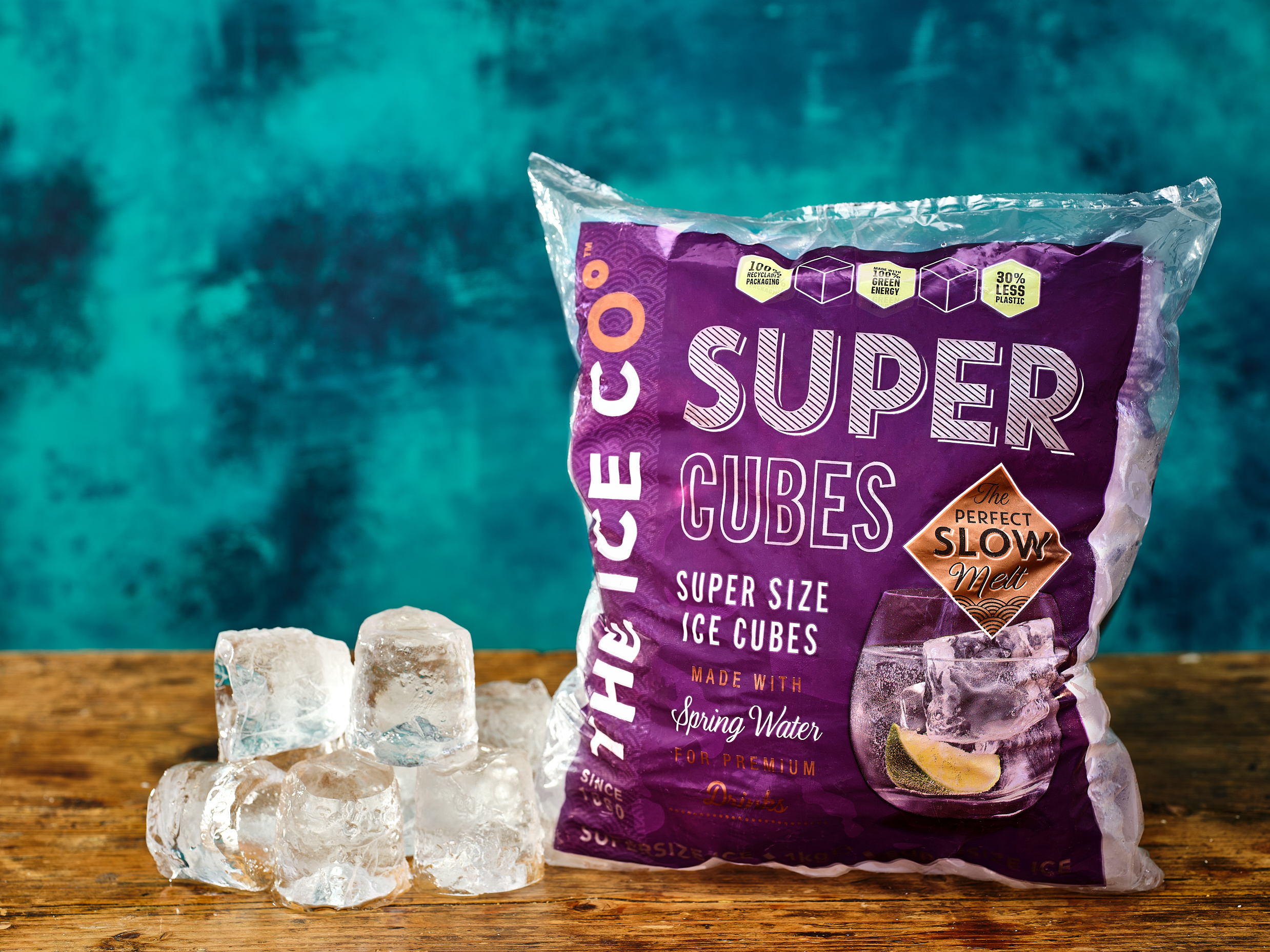 Bag of The Ice Co. Super Cubes on a wooden surface on a blue background