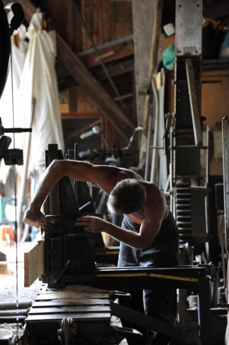 photo d'un homme dans un atelier en train de travailler le bois 