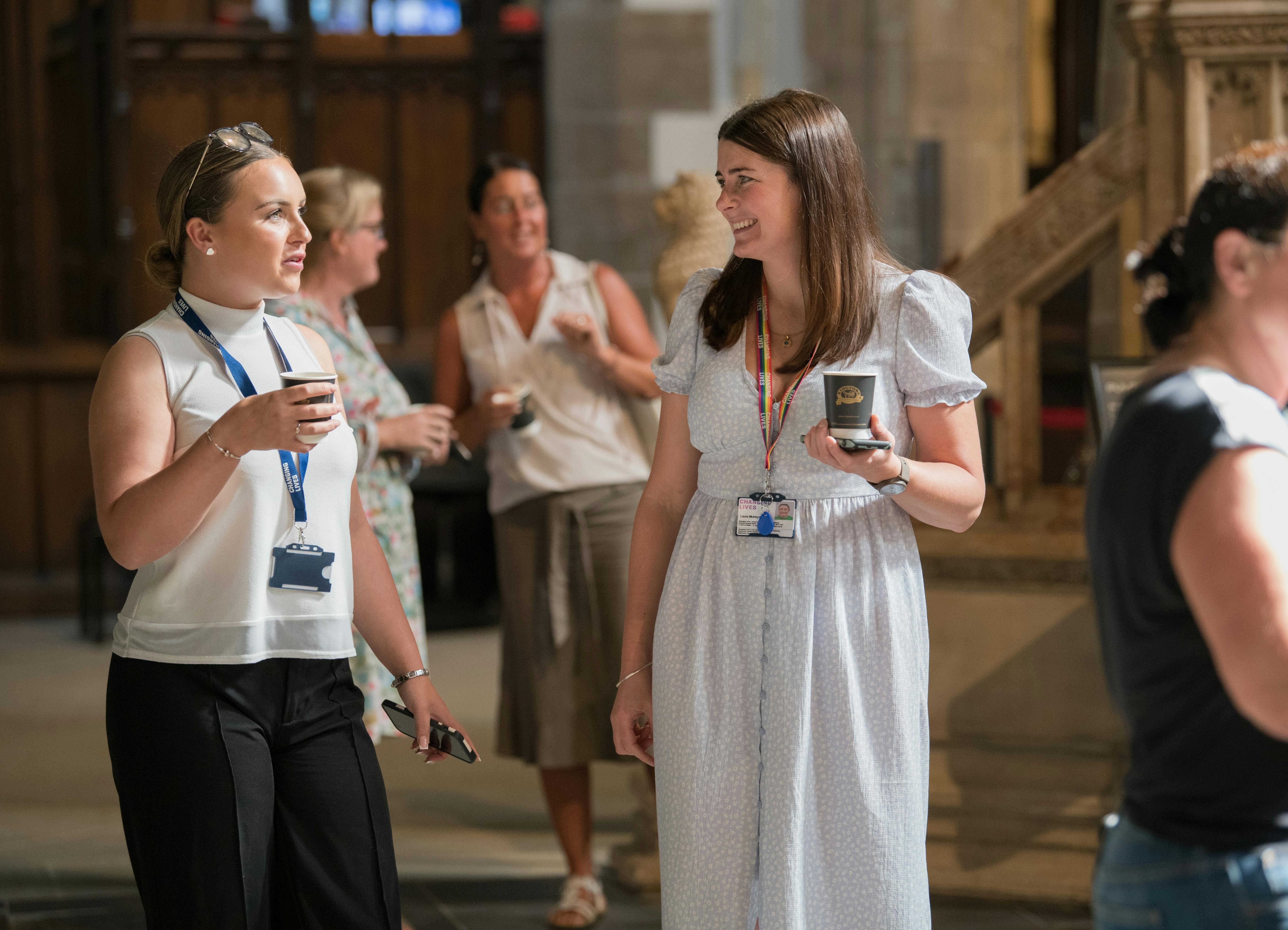 Two Female Changing Lives Staff Members Conversing at an Event.