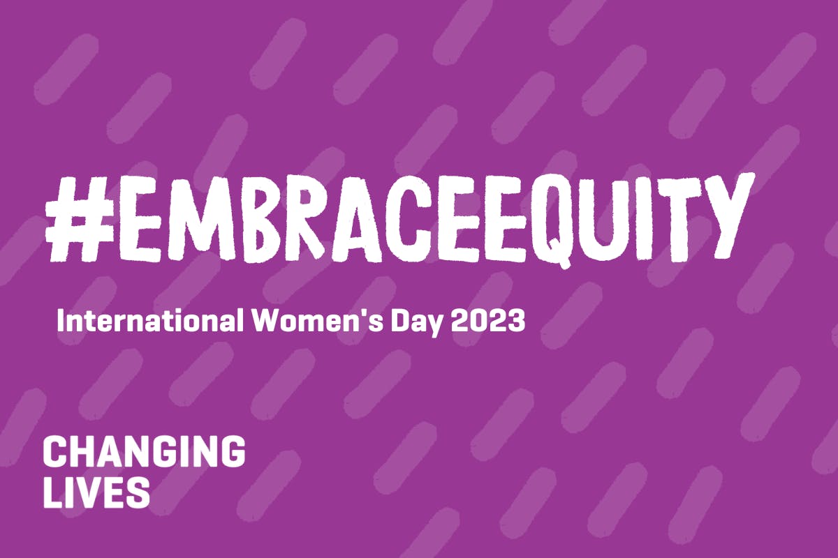 Purple background with lighter purple pill pattern reading " #EmbraceEquity International Women's Day 2023" and the Changing Lives logo.