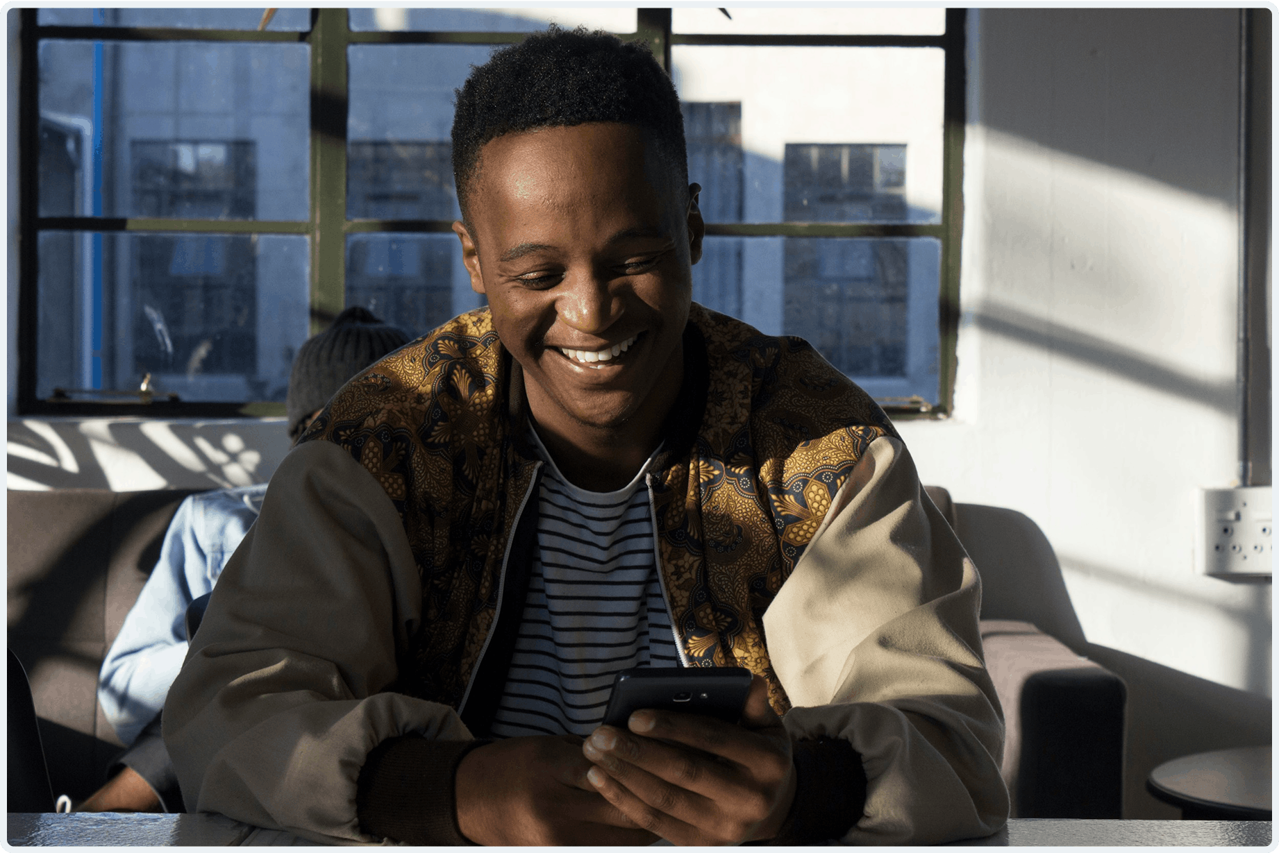 A young man smiling at his phone