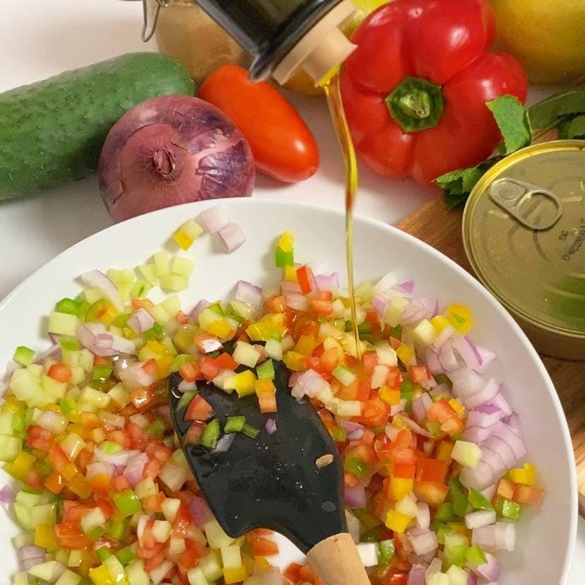 Pouring olive oil salad