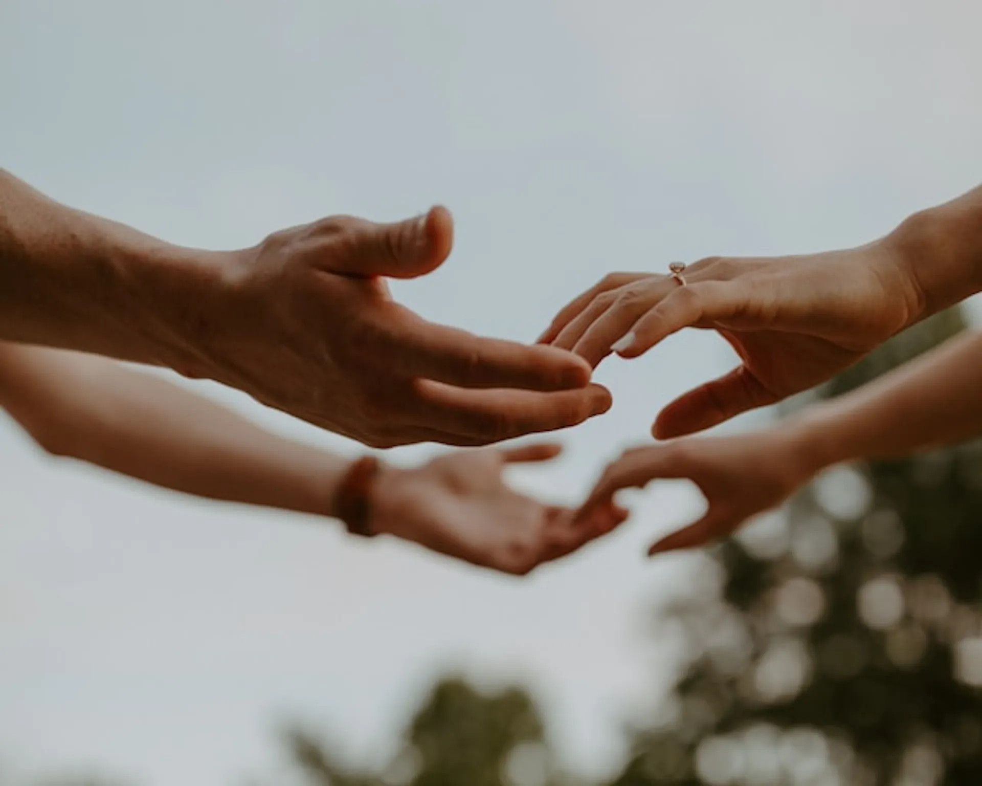 Four hands about to touch Photo by Hannah Busing on Unsplash